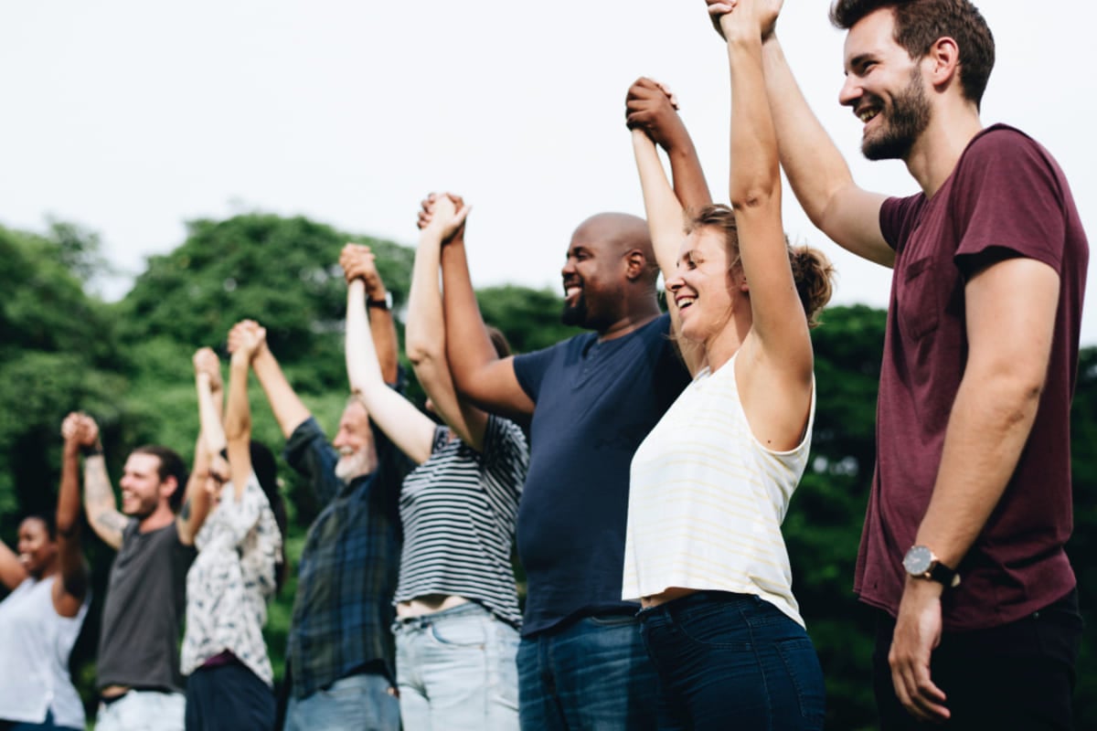 Об’єднання людей- A group of smiling people holding hands together, Kenwood Management Company investor family concept