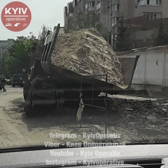 В Киеве в яме посреди дороги застрял грузовик с песком (ФОТО)